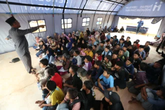 Guru mengajar di sekolah darurat bantuan Human Initiative di posko pengungsian Desa Durian, Aceh Tamiang, Aceh