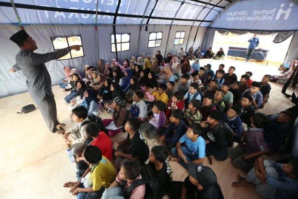 Guru mengajar di sekolah darurat bantuan Human Initiative di posko pengungsian Desa Durian, Aceh Tamiang, Aceh