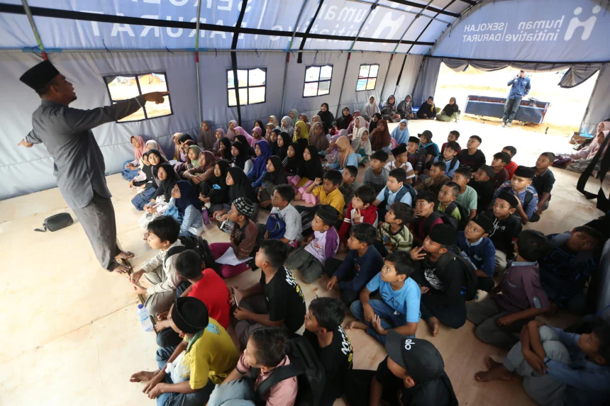 Guru mengajar di sekolah darurat bantuan Human Initiative di posko pengungsian Desa Durian, Aceh Tamiang, Aceh