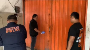 Petugas Kepolisian saat memeriksa toko tempat kejadian perkara