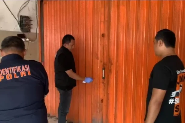 Petugas Kepolisian saat memeriksa toko tempat kejadian perkara