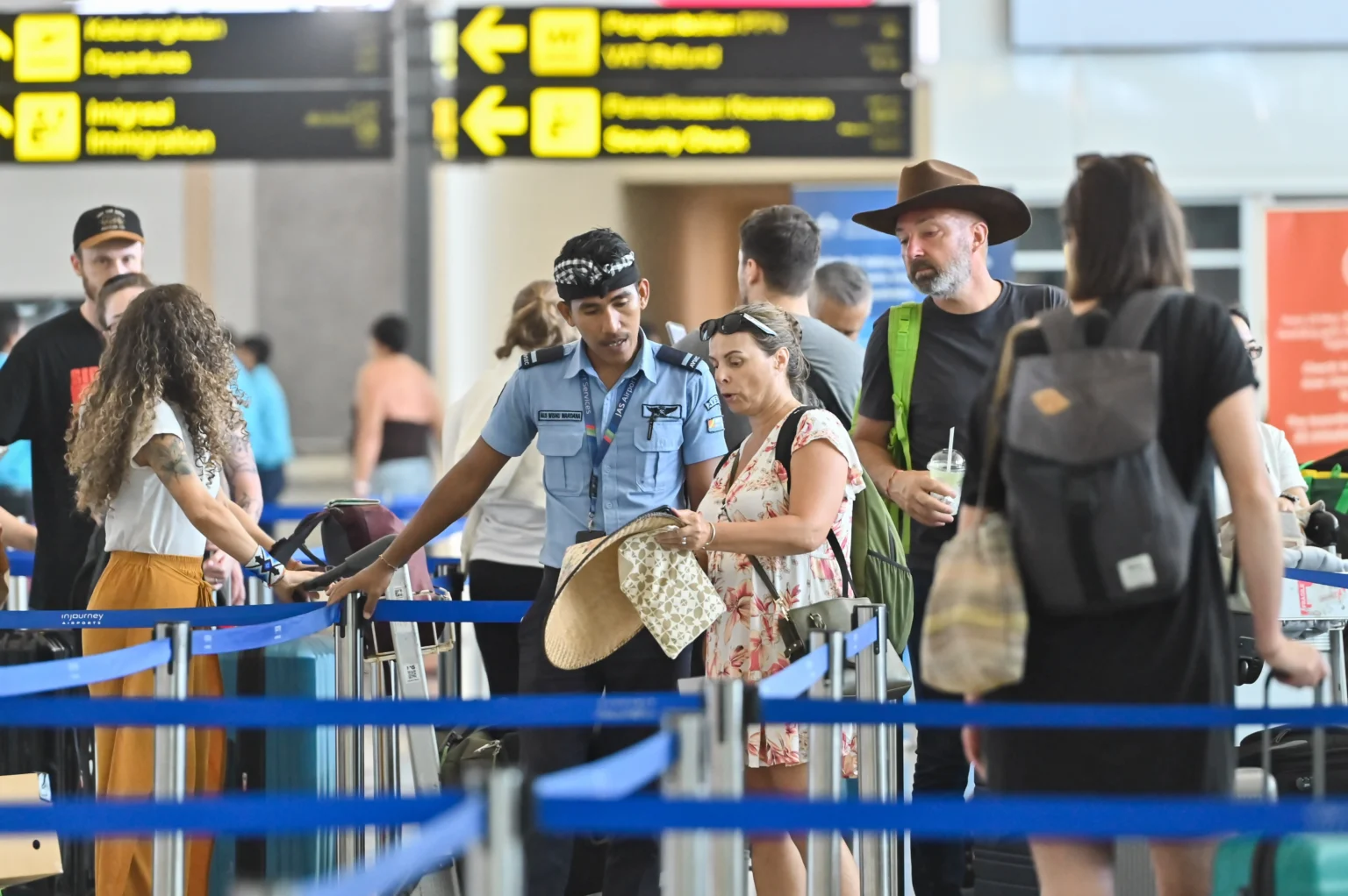 Petugas memberikan informasi kepada penumpang pesawat di Terminal Keberangkatan Internasional Bandara Internasional I Gusti Ngurah Rai, Badung, Bali