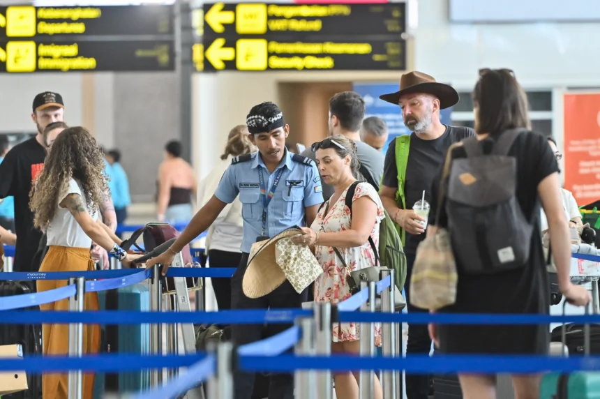 Petugas memberikan informasi kepada penumpang pesawat di Terminal Keberangkatan Internasional Bandara Internasional I Gusti Ngurah Rai, Badung, Bali