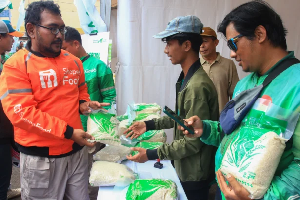 Sejumlah pengemudi ojek daring menerima beras Zakat Fitrah yang diberikan oleh Dompet Dhuafa dalam program Ber-Ojol (Berkah untuk Ojol) di Ciputat, Tangerang