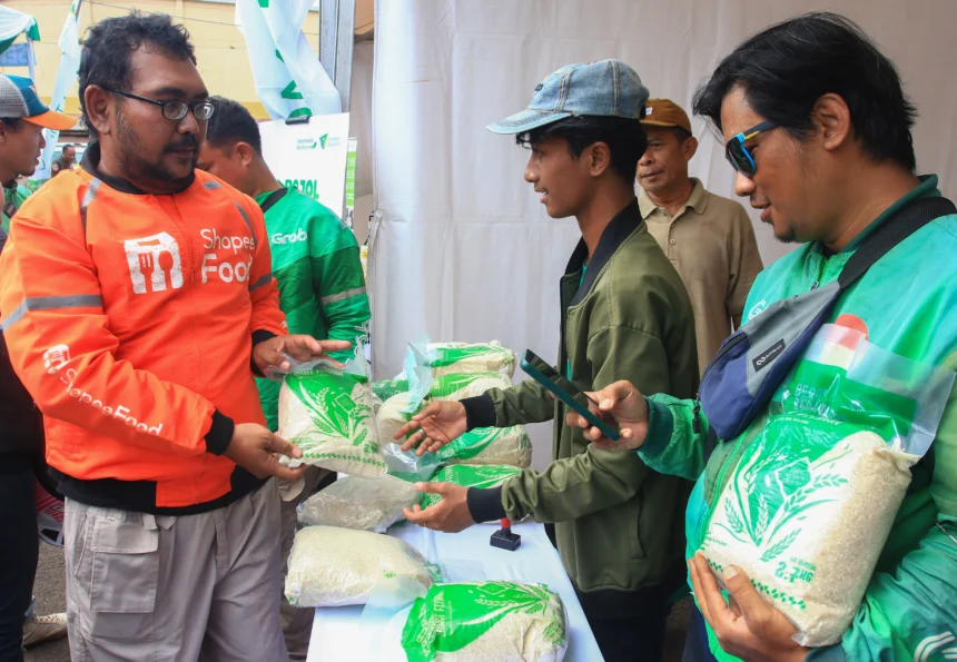 Sejumlah pengemudi ojek daring menerima beras Zakat Fitrah yang diberikan oleh Dompet Dhuafa dalam program Ber-Ojol (Berkah untuk Ojol) di Ciputat, Tangerang