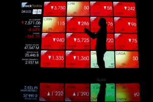 Pengunjung melintas di depan layar yang menampilkan pergerakan Indeks Harga Saham Gabungan (IHSG) di Bursa Efek Indonesia, Jakarta.