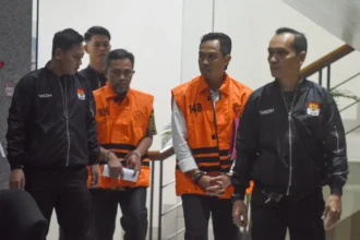 Bupati Cilacap Syamsul Auliya Rachman (kedua kanan) dan dan Sekda Kabupaten Cilacap Sadmoko Danardono (tengah) mengenakan rompi tahanan KPK usai menjalani pemeriksaan di Gedung Merah Putih KPK, Jakarta.