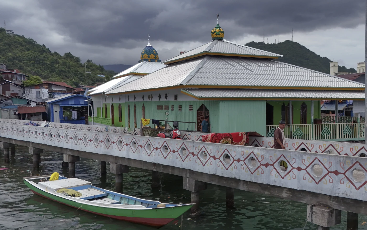 Warga berjalan di dekat Masjid Al Muhajirin di Kampung Nelayan Hamadi, Jayapura, Papua