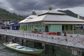 Warga berjalan di dekat Masjid Al Muhajirin di Kampung Nelayan Hamadi, Jayapura, Papua