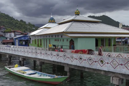 Warga berjalan di dekat Masjid Al Muhajirin di Kampung Nelayan Hamadi, Jayapura, Papua