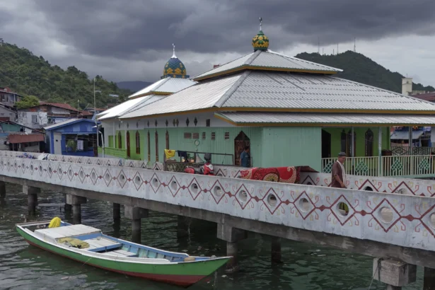 Warga berjalan di dekat Masjid Al Muhajirin di Kampung Nelayan Hamadi, Jayapura, Papua