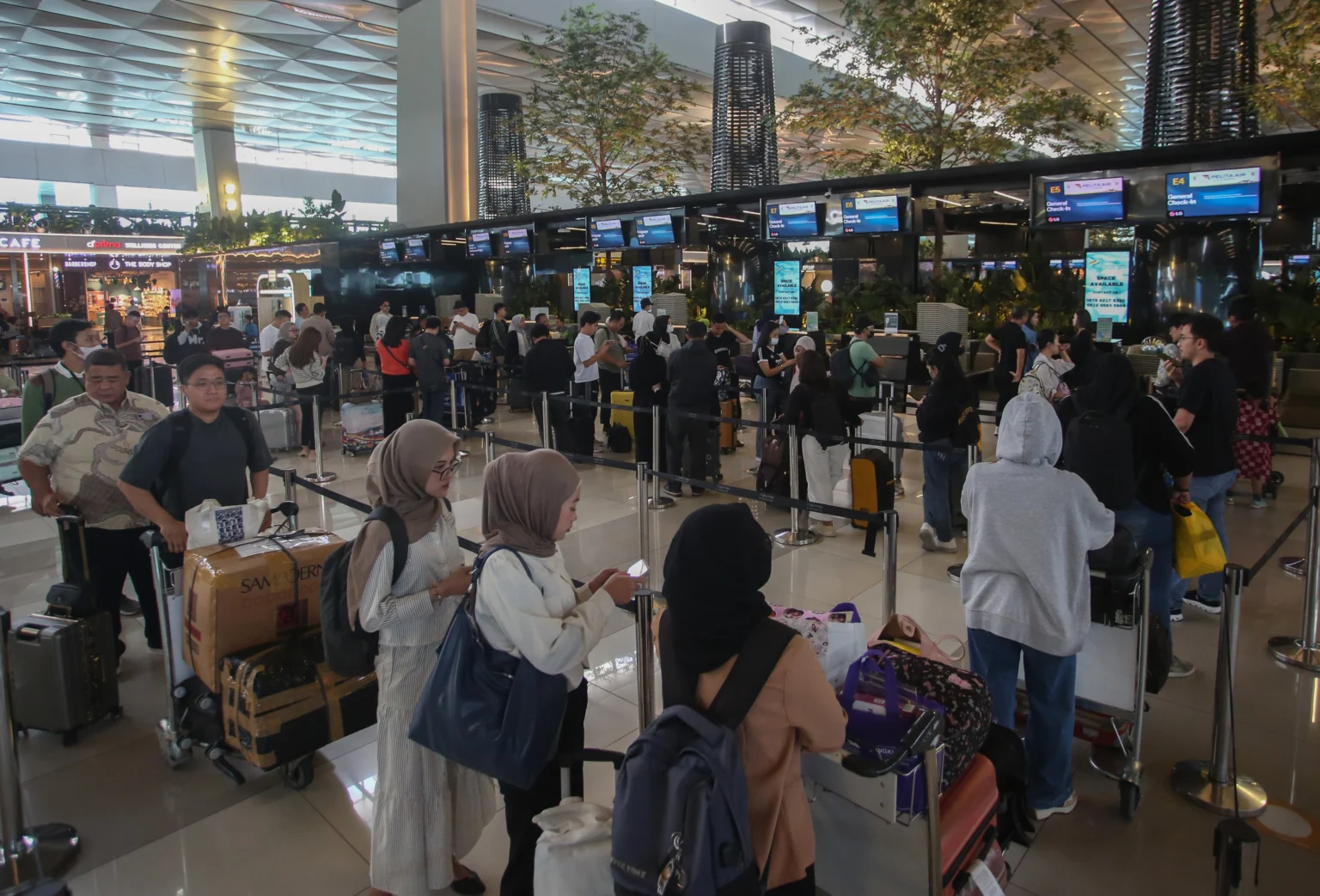 Calon penumpang pesawat antre untuk lapor diri di Terminal 3 Bandara Soekarno Hatta, Tangerang, Banten.