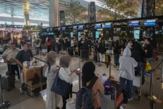 Calon penumpang pesawat antre untuk lapor diri di Terminal 3 Bandara Soekarno Hatta, Tangerang, Banten.