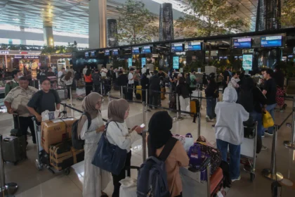 Calon penumpang pesawat antre untuk lapor diri di Terminal 3 Bandara Soekarno Hatta, Tangerang, Banten.