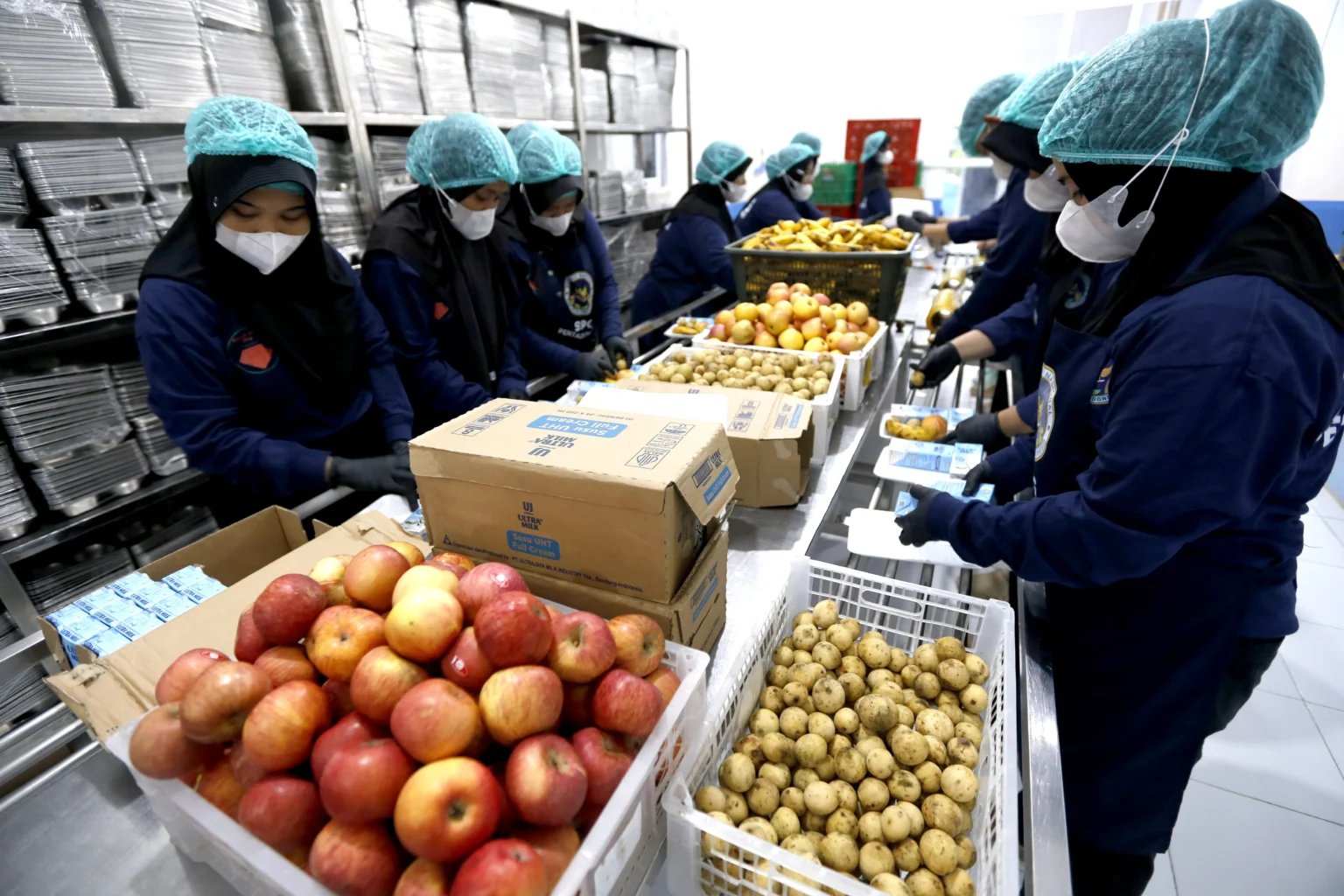 Sejumlah karyawan mengemas paket makanan bergizi gratis (MBG) di Satuan Pelayanan Pemenuhan Gizi (SPPG) Pentadio Barat, Kabupaten Gorontalo, Gorontalo