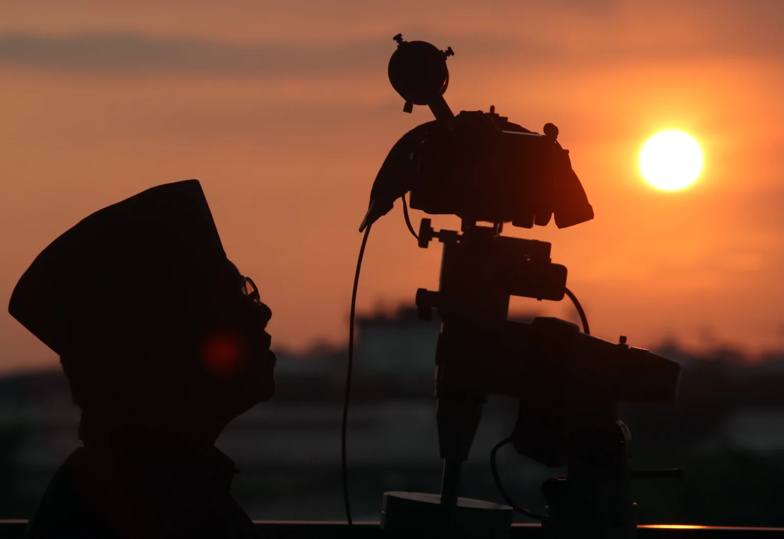 Anggota tim dari Lembaga Falakiyah Pengurus Wilayah Nahdlatul Ulama DKI Jakarta dengan menggunakan teleskop mengamati hilal di Masjid Hasyim Asyari, Jakarta.