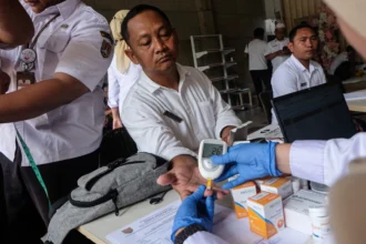 Petugas mengukur gula darah sopir travel dalam giat pemeriksaan kesehatan bagi pengemudi masa angkutan Lebaran di Travel Kencana, Semarang, Jawa Tengah,