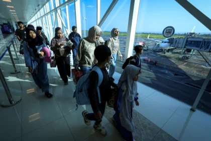 Penumpang berjalan untuk menaiki pesawat di Bandara Internasional Juanda Surabaya, Jawa Timur