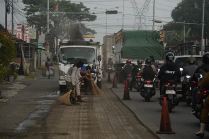 Pekerja menyapu serpihan aspal saat perbaikan Jalan Nasional Jogja-Solo di Klaten, Jawa Tengah