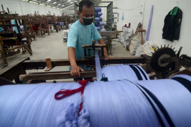 Pekerja menyelesaikan penggulungan benang untuk pembuatan kain sarung menggunakan alat tenun bukan mesin (ATBM) di Industri kain sarung Pohon Korma Desa Pacul, Kabupaten Tegal, Jawa Tengah