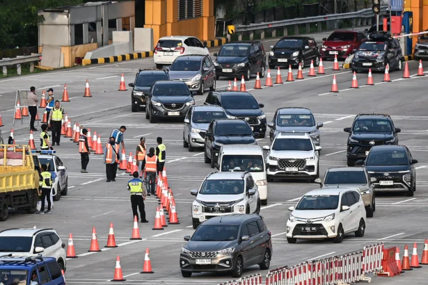 Petugas mengatur arus lalu lintas kendaraan yang melintas di Gerbang Tol Cikampek Utama, Karawang, Jawa Barat