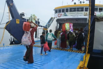 Calon penumpang berjalan memasuki kapal feri di Pelabuhan Jangkar, Situbondo, Jawa Timur,
