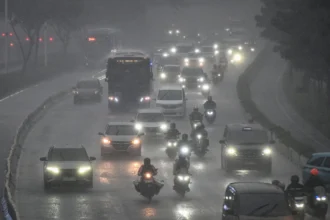 Kendaraan bermotor melintas saat hujan lebat di Jalan Sudirman, Jakarta