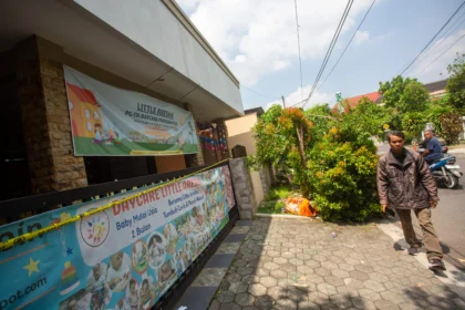 Warga melintas di dekat penitipan anak atau daycare Little Aresha yang disegel polisi di Umbulharjo, Yogyakarta