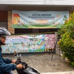 Warga melintas di dekat penitipan anak atau daycare Little Aresha yang disegel polisi di Umbulharjo, Yogyakarta