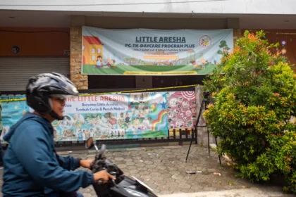Warga melintas di dekat penitipan anak atau daycare Little Aresha yang disegel polisi di Umbulharjo, Yogyakarta
