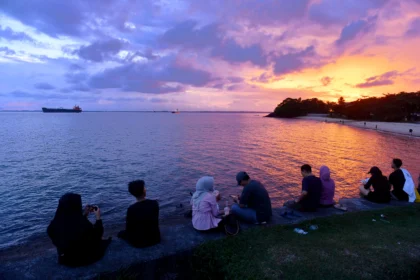 Wisatawan menikmati suasana saat matahari terbenam di Pantai Kilang Mandiri, Balikpapan, Kalimantan Timur,