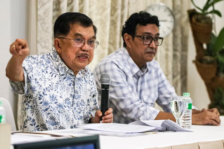 Wakil Presiden RI ke-10 dan ke-12 Jusuf Kalla (kiri) didampingi juru bicara Husain Abdullah memberikan keterangan pers di kediamannya di Jakarta, Sabtu (18/4/2026).