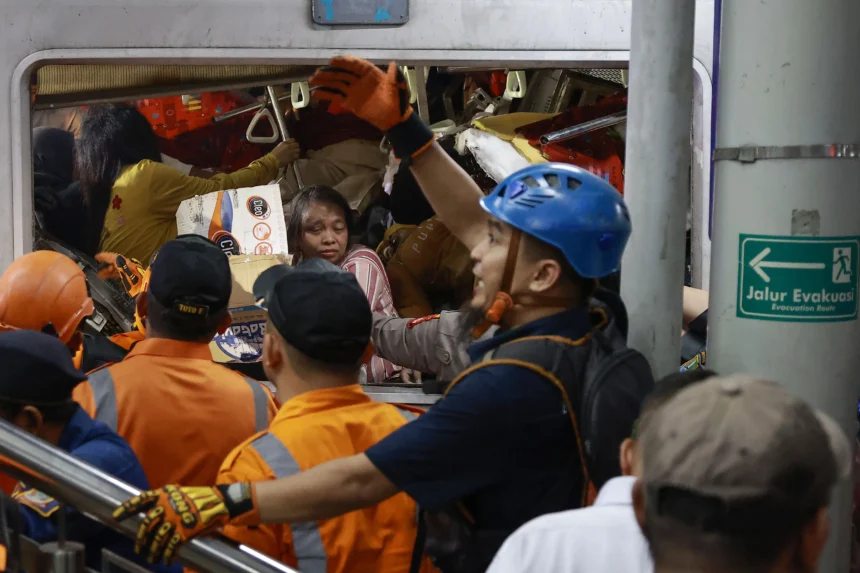 Petugas mengevakuasi korban yang masih terjebak di dalam gerbong KRL Commuterline yang bertabrakan dengan KA Argo Bromo Anggrek relasi Gambir-Surabaya Pasar Turi di Stasiun Bekasi Timur, Bekasi