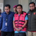 Penyidik Kejaksaan Agung mengawal Ketua Ombudsman RI 2026 - 2031 Hery Susanto (kedua kanan) seusai menjalani pemeriksaan dan penetapan tersangka di Gedung Bundar Jampidsus Kejaksaan Agung, Jakarta.