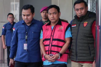 Penyidik Kejaksaan Agung mengawal Ketua Ombudsman RI 2026 - 2031 Hery Susanto (kedua kanan) seusai menjalani pemeriksaan dan penetapan tersangka di Gedung Bundar Jampidsus Kejaksaan Agung, Jakarta.