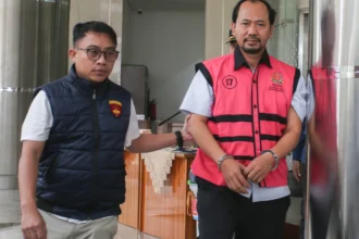 Penyidik mengawal Agung Winarno (kanan) saat menuju mobil tahanan di Gedung Bundar Jampidsus, Kejaksaan Agung, Jakarta.