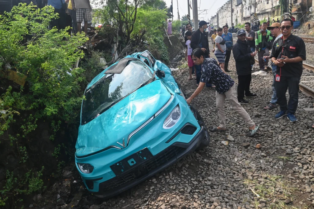 Warga mengamati taksi listrik Green SM yang rusak pascakecelakaan dengan KRL Commuter Line dan KA Argo Bromo Anggrek di Bekasi Timur, Bekasi, Jawa Barat, Selasa (28/4/2026). Komite Nasional Keselamatan Transportasi (KNKT) mengerahkan tim investigasi untuk mengumpulkan fakta terkait kecelakaan kereta api di Stasiun Bekasi Timur pada Senin (27/4) malam.