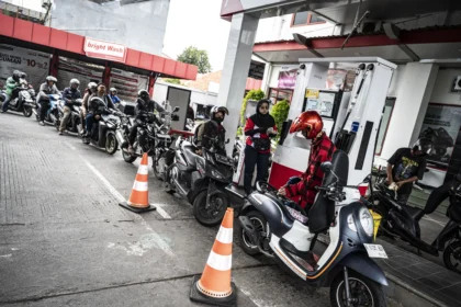 Pengendara sepeda motor mengisi bahan bakar minyak (BBM)