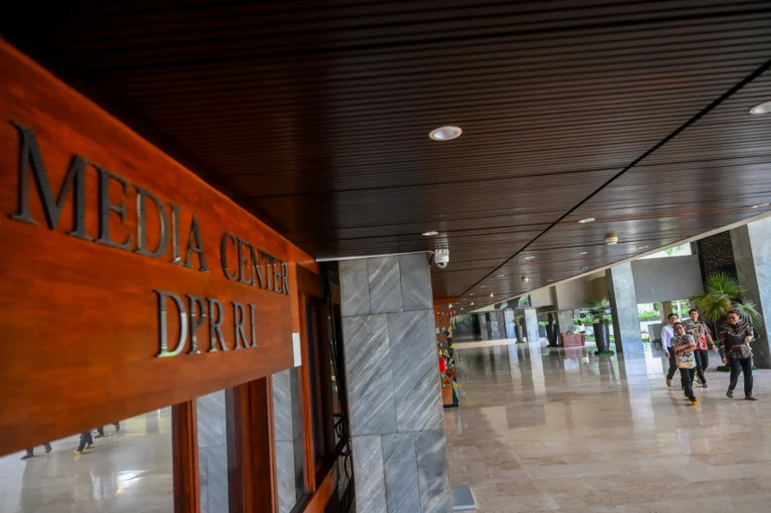 Pegawai berjalan di kawasan Gedung Nusantara II, Kompleks Parlemen, Senayan, Jakarta