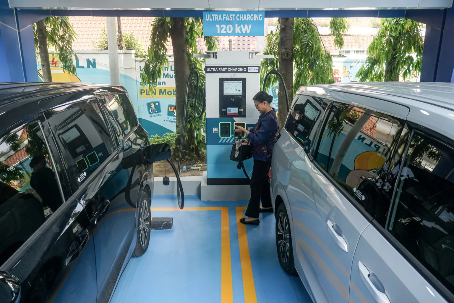 Pengguna kendaraan listrik mengisi daya mobilnya di Stasiun Pengisian Kendaraan Listrik Umum (SPKLU) PLN UP3, Solo, Jawa Tengah