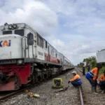 Pekerja beristirahat usai melakukan perawatan rel kereta api di kawasan Cigugur Tengah, Kota Cimahi, Jawa Barat