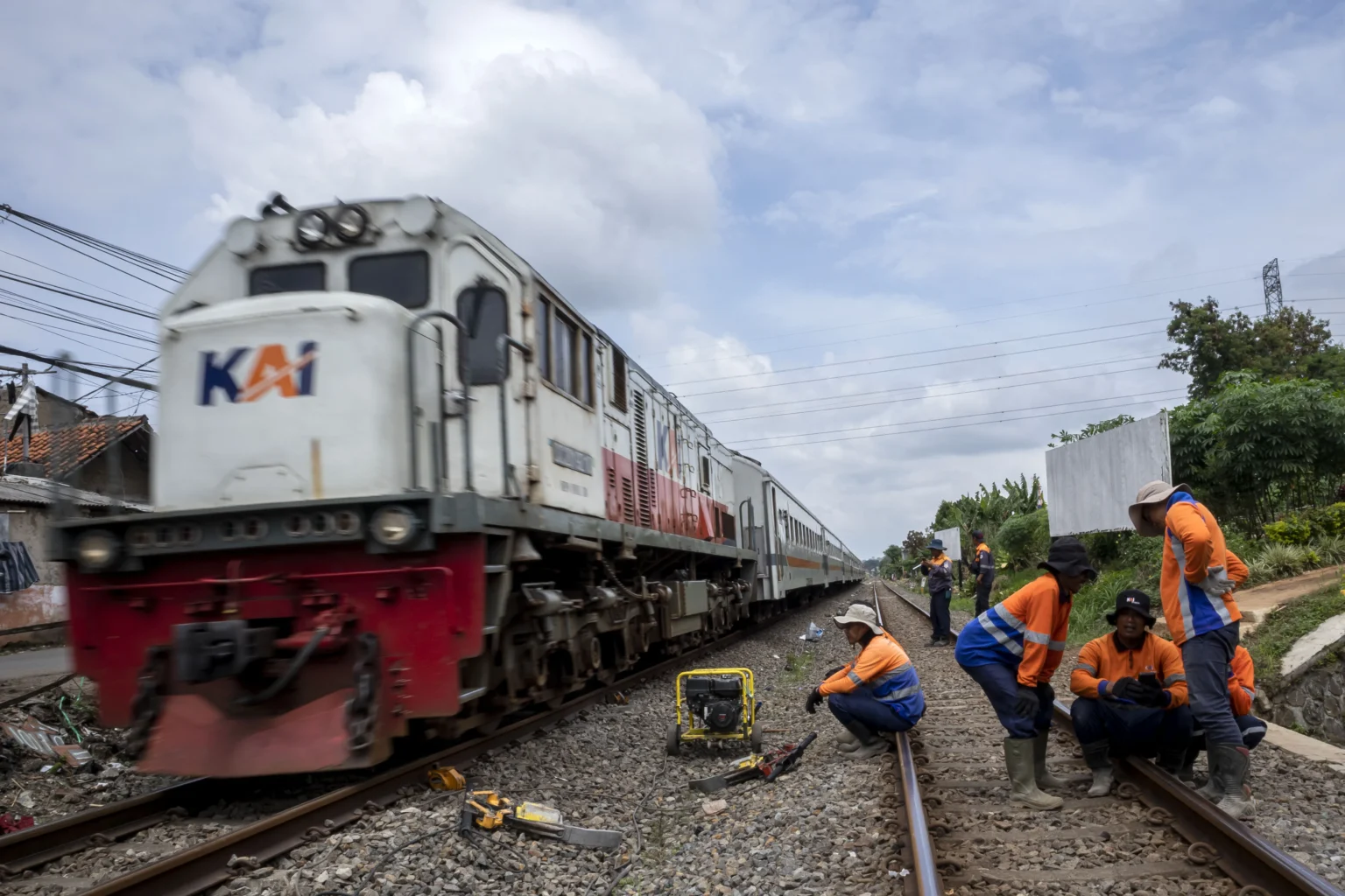 Pekerja beristirahat usai melakukan perawatan rel kereta api di kawasan Cigugur Tengah, Kota Cimahi, Jawa Barat