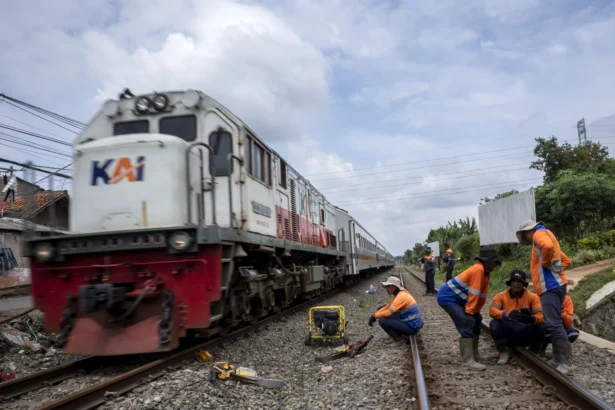 Pekerja beristirahat usai melakukan perawatan rel kereta api di kawasan Cigugur Tengah, Kota Cimahi, Jawa Barat