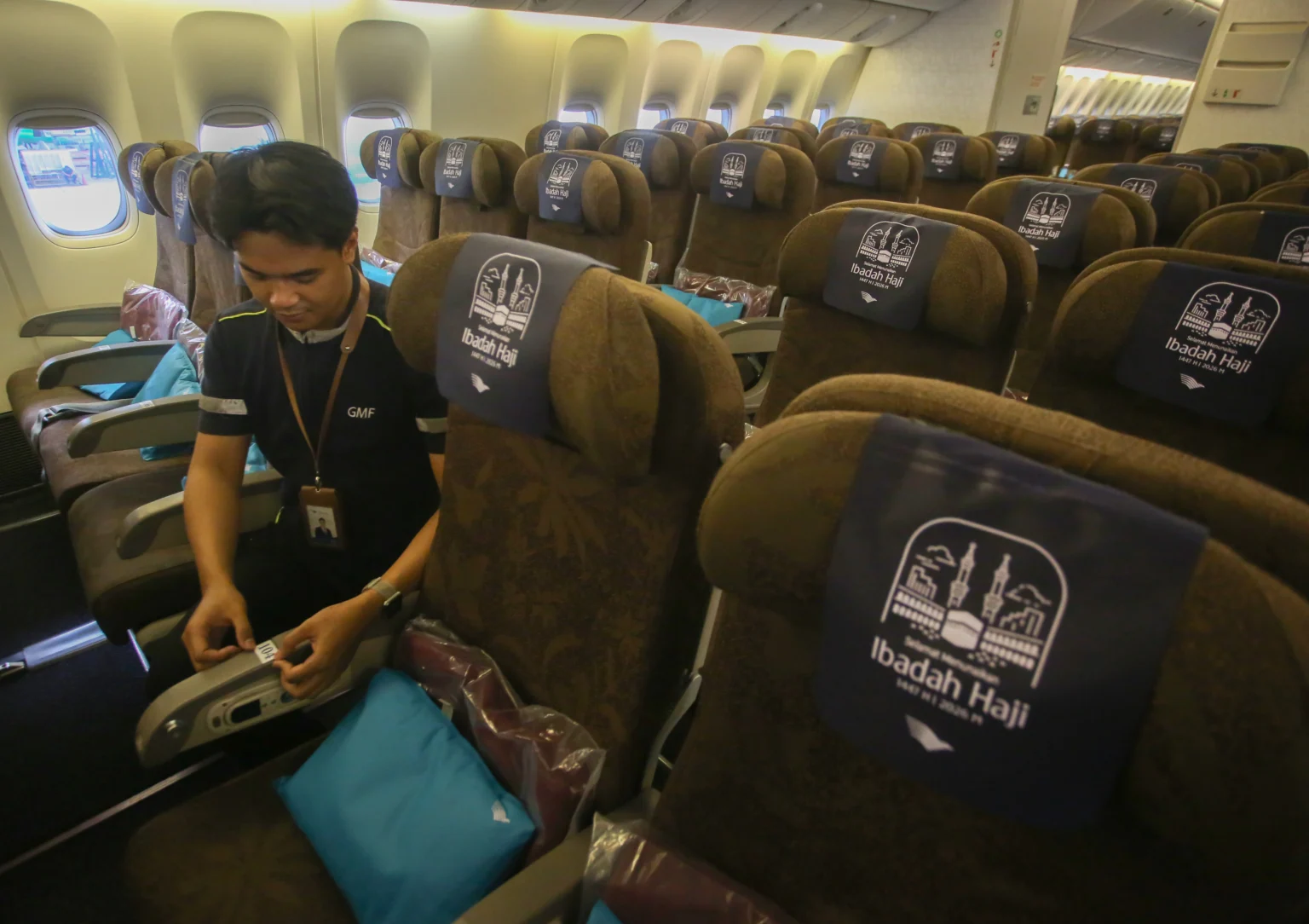 Pekerja memasang nomor urut tempat duduk di pesawat Garuda Indonesia yang akan digunakan untuk armada angkutan haji 1447 H/2026 di hanggar GMF Bandara Soekarno Hatta, Tangerang, Banten