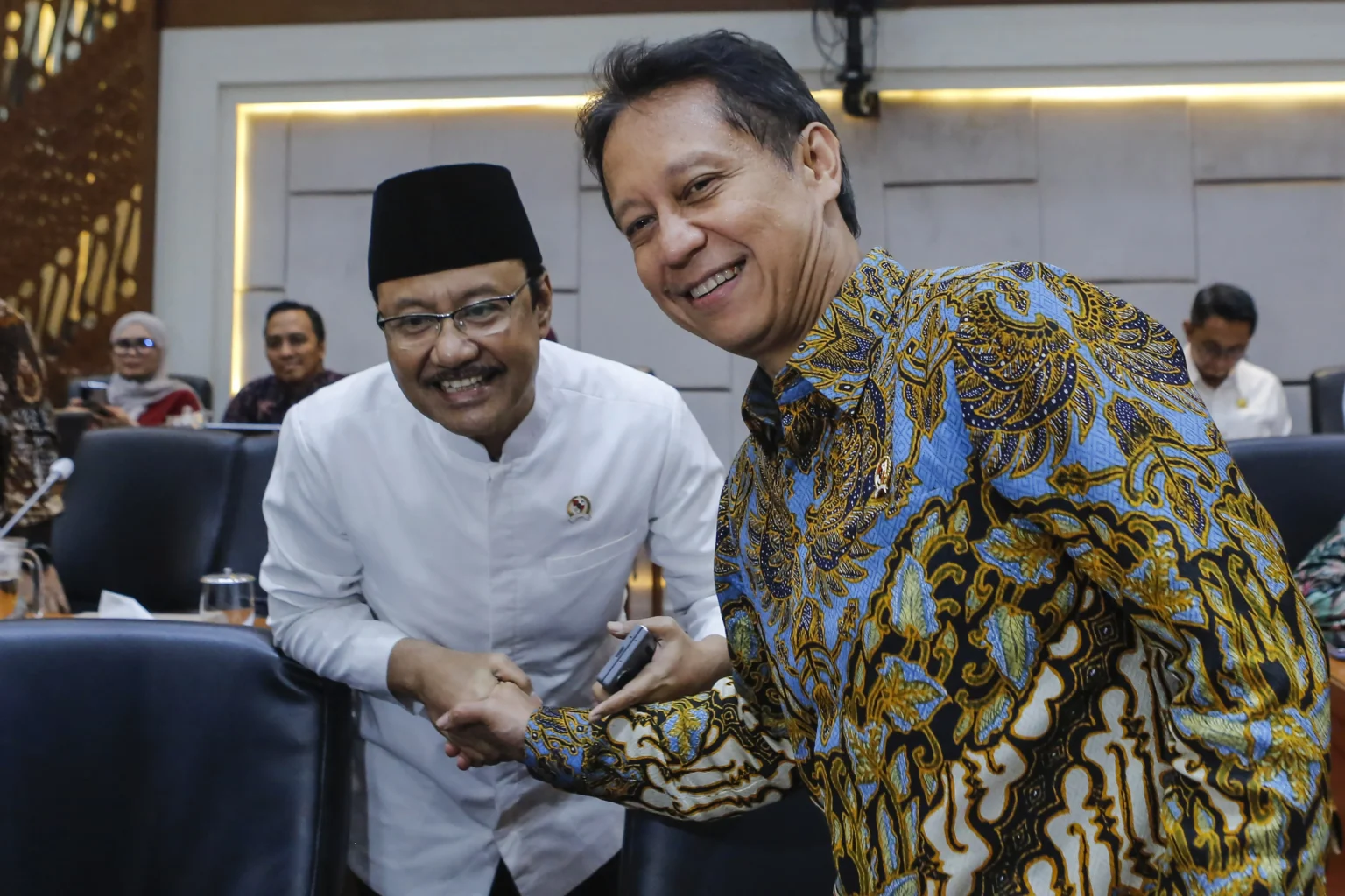 Menteri Kesehatan Budi Gunadi Sadikin (kanan) berjabat tangan dengan Menteri Sosial Saifullah Yusuf (kiri) sebelum mengikuti rapat kerja dengan Komisi IX DPR di Kompleks Parlemen, Senayan, Jakarta