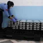 Relawan menata wadah Makan Bergizi Gratis di dapur Satuan Pelayanan Pemenuhan Gizi (SPPG) di Kota Malang, Jawa Timur