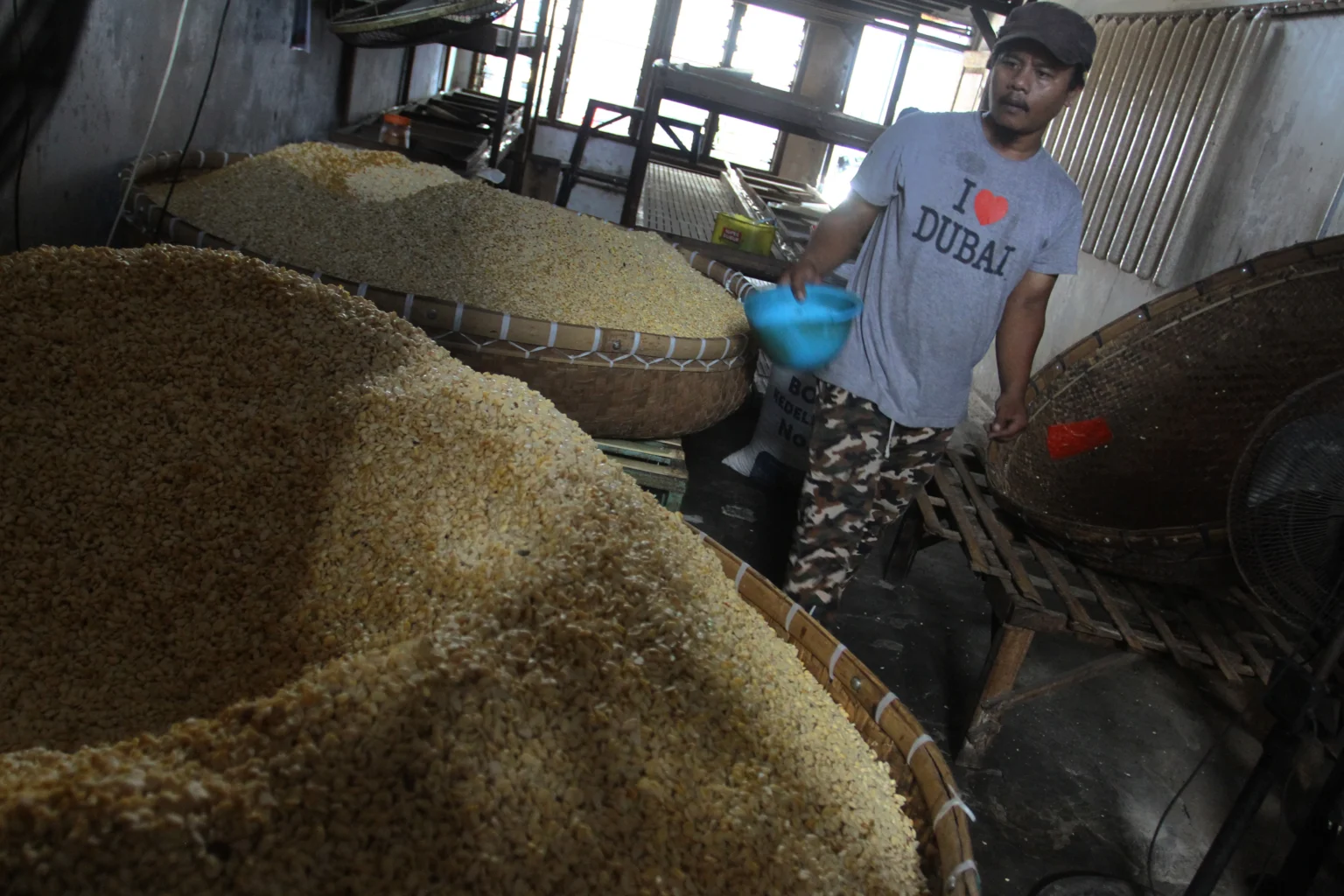 Perajin mencampurkan ragi dengan kedelai giling di Sentra Industri Tempe Sanan, Kota Malang, Jawa Timur