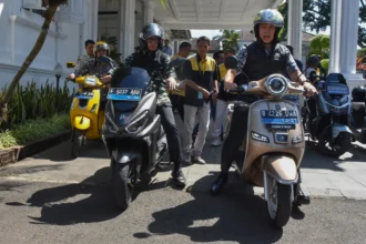Wakil Menteri Dalam Negeri Bima Arya (kedua kiri) bersama Wali Kota Bogor Dedie A Rachim (kanan) mengendarai sepeda motor listrik saat bersiap untuk sidak pelaksanaan Work From Home (WFH) di Balaikota Bogor, Jawa Barat