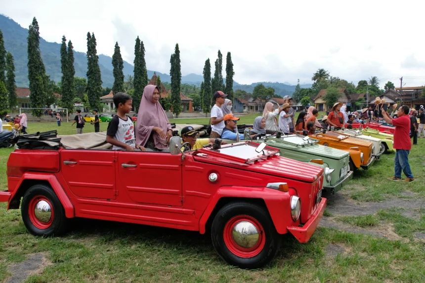 Wisatawan berpose di atas mobil volkswagen (VW) safari di lapangan Randualas kawasan Pegunungan Menoreh Desa Tuksongo, Borobudur, Magelang, Jawa Tengah