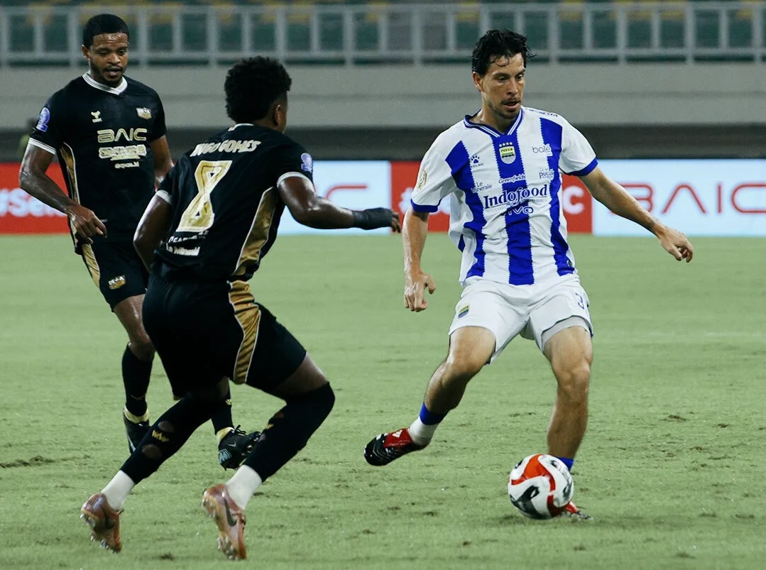 Pemain Persib Bandung, Tom Haye, dihadang saat membawa bole oleh pemain Dewa United